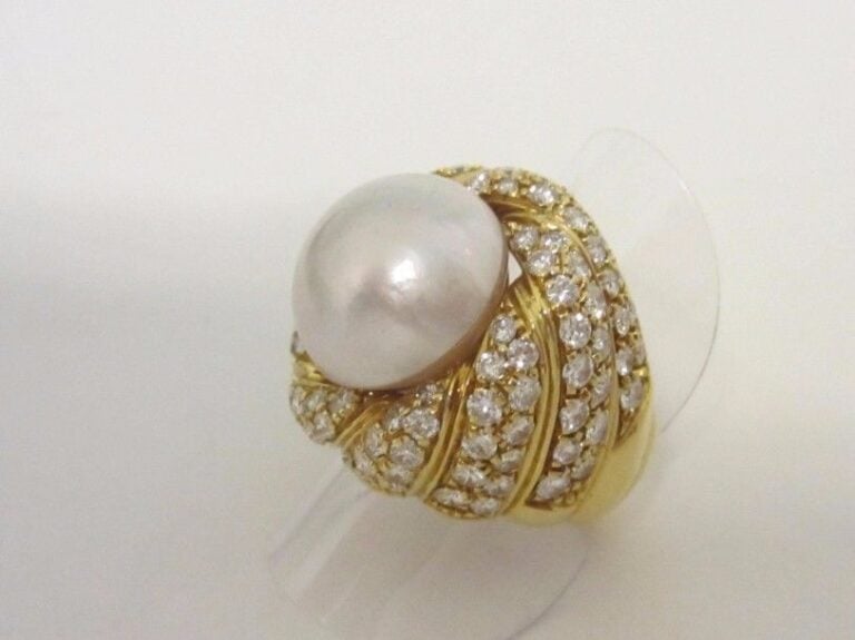 . Importante BAGUE en or jaune (750 millièmes) godronné et torsadé serti d’une perle Mabé partiellement entourée de diamants taille brillant.