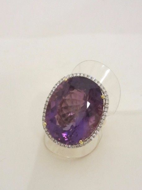 Importante BAGUE en or jaune (750 millièmes) serti d’une améthyste de forme ovale entourée de diamants taille brillan