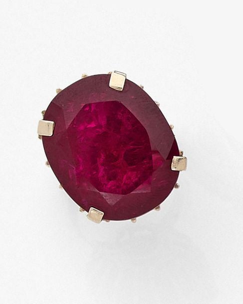 •Importante BAGUE en or jaune (750‰) serti d'un important rubis traité de forme coussi