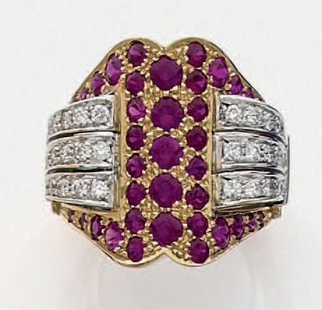 Importante BAGUE en or jaune et or gris (750 millièmes) ciselé et pavé de rubis, épaulé de godrons sertis de diamants taille brillan