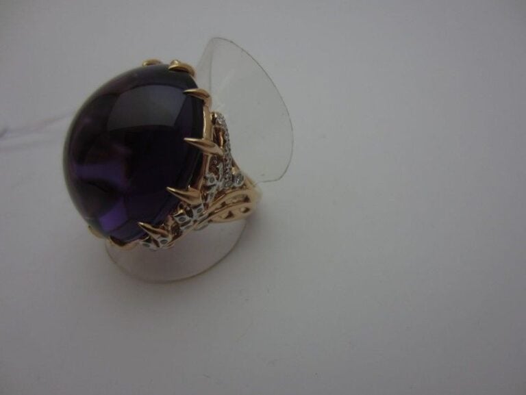 Importante BAGUE en or rose (750 millièmes) ajouré serti d'une importante améthyste cabochon de forme ovale épaulée de petits diamant