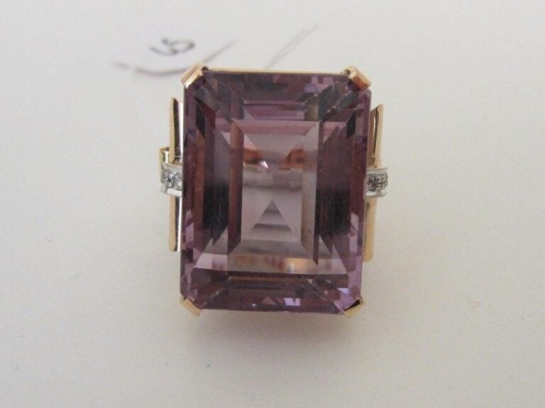 Importante BAGUE en or rose et or gris 14 carats (585 millièmes) serti d'une améthyste rectangulaire taillée à degrés, épaulé de rouleaux sertis deux lignes de diamant