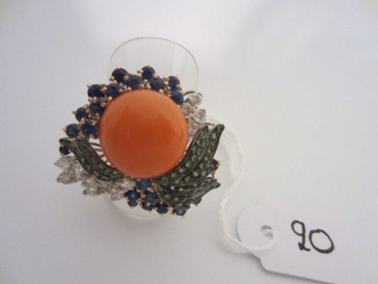 Importante BAGUE «feuilles» en or gris, rose, jaune et or noirci (750 millièmes) serti d?un cabochon de corail, saphirs, grenats et diamant