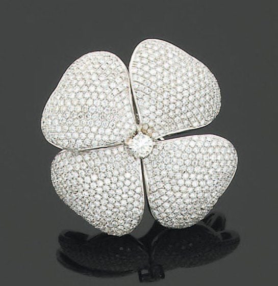 Importante BAGUE « fleur » en or gris pavé de diamants de taille brillant, sertie au centre d'un diamant plus importan
