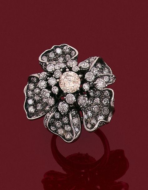 •Importante BAGUE «fleur» en or noirci (750‰) pavé de diamants taille brillant, dont un au centre plus importan
