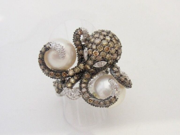Importante BAGUE « octopus » en or gris et or noirci (750 millièmes) serti de diamants bruns et blancs, épaulés de deux perles de cultures blanche