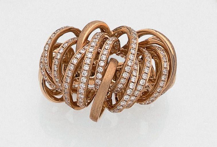 Importante BAGUE « tourbillons » en or rose (750 millièmes) ajouré, polis et satiné partiellement serti de diamants taille brillan