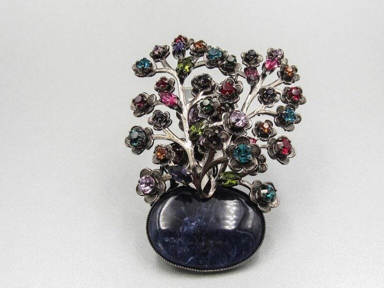 Importante broche pierre bleue ovale surmontée de rameaux de fleurs ornées de pierres multicolore