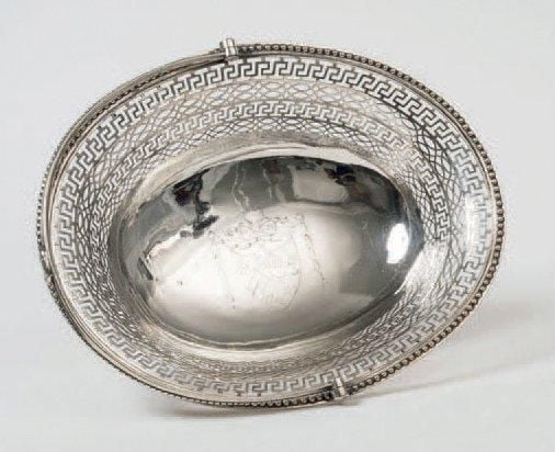 IMPORTANTE CORBEILLE À ANSE, à motif ajouré de grecques et d'entrelacs, la bordure perlée reposant sur un piédouche ajouré d'un motif floral stylisé; le fond gravé d'un noeud de ruban retenant un blason armori