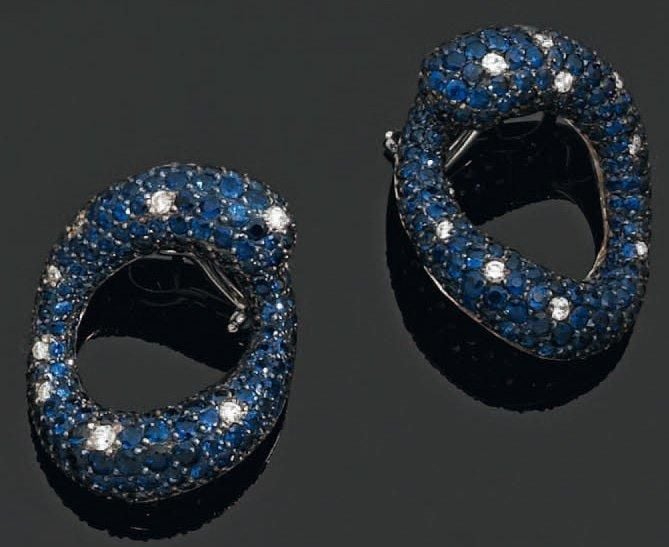 Importante paire de BOUCLES D'OREILLES circulaires en or gris et or noirci bombé, pavé de saphirs et ponctué de diamant
