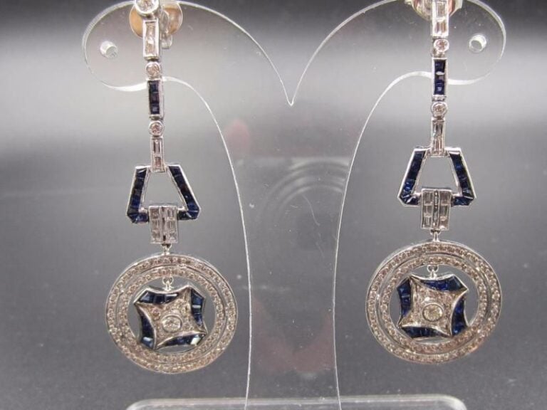 Importante PAIRE de PENDANTS D’OREILLES en or gris (750 millièmes) ajouré à motifs géométriques et circulaire serti de saphirs calibrés, diamants baguettes et taille brillan