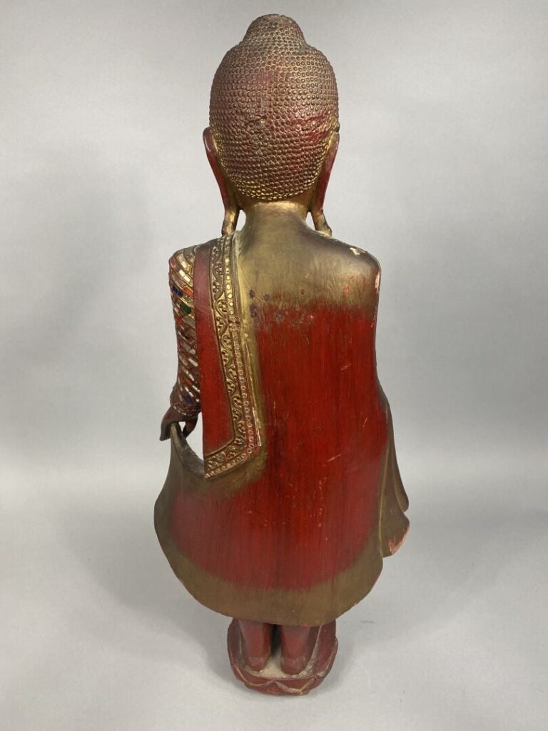 Indonésie - Sujet en bois rouge et doré sculpté figurant bouddha debout tenant…