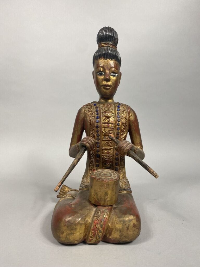 Indonésie - Sujet en bois rouge et doré sculpté figurant bouddha debout tenant…