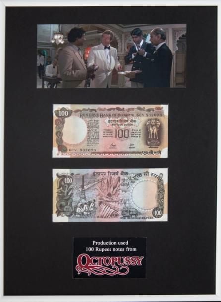 James Bond Billets de banque de 100 Roupies, Octopussy 1983 Etats-Unis Dimensions des billets: 15,5 x 7 cm Dimensions du cadre: 40 x 30 cm Lorsque James Bond (Roger Moore) rencontre Kamal Khan (Louis Jourdan) la première fois à Delhi (Inde), il le bat au backgammon et son gain lui est payé sous la forme de billets de ce typ