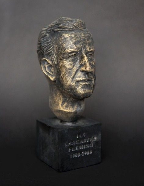 James Bond Buste de l'auteur à succès de Ian Fleming, coulé en résine puis peint et monté sur un support de bloc de bois, avec une inscription gravée sur sa base, Ian Lancaster Fleming, 1908-196