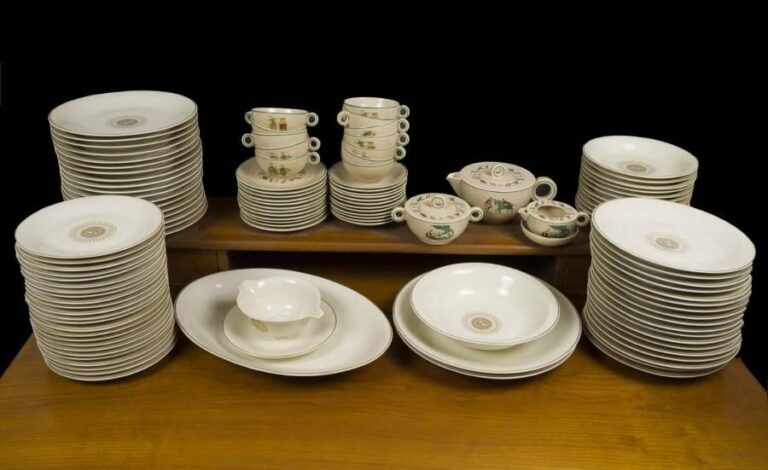 Jean LUCE (1895-1964) Partie de service à dîner de commande en porcelaine blanche ornée de filets d'or et de soleils irradiants fléchés chiffrés "JDAL