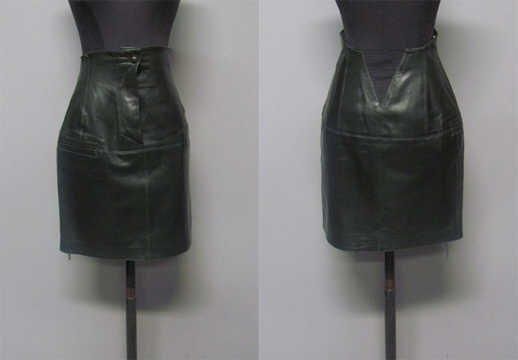 JUPE courte et droite à taille haute en agneau plongé vert bouteille, deux fausses poches passepoilées et petit élastique au dos (griffe blanche, graphisme noir) (env TS)