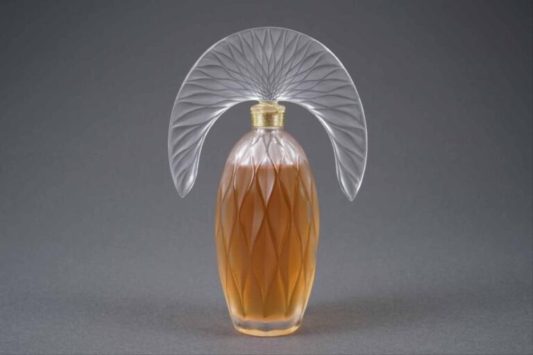 LALIQUE FRANCE Modèle "Commedia de Lalique" Flacon de parfum en cristal à décor losangé en léger relief, le bouchon tiare figurant un feuillage stylisé en relief sur une fac