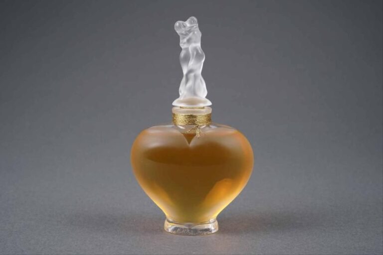 LALIQUE FRANCE Modèle "L'Amour" Flacon de parfum en cristal dépoli de forme coeur, son bouchon en cristal satiné à décor d'amoureux s'enlaçan