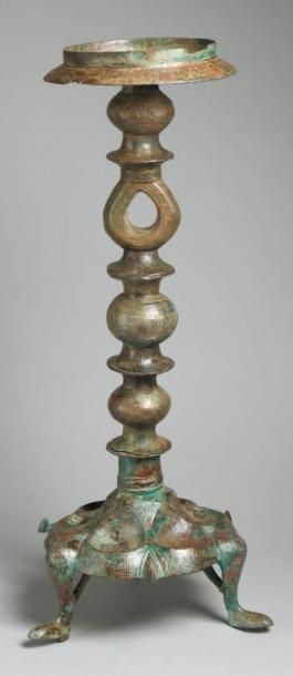 LAMPE Lampe en bronze, à base tripode polylobée creusée de six alvéoles lotiformes, décorée d'inscriptions coufique