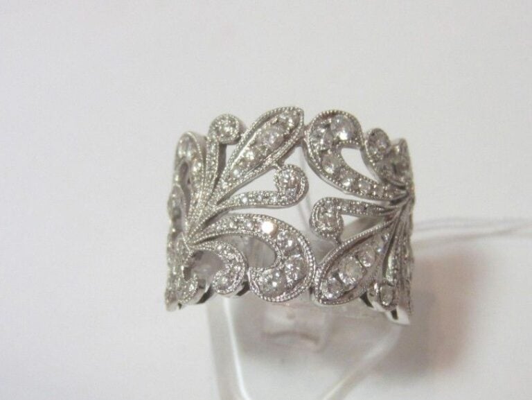 Larg BAGUE «fleurs» en or gris (750 millièmes) partiellement ajouré serti de diamants taille brillant