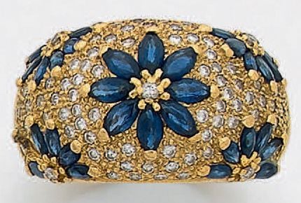 Large BAGUE bombée en or jaune (750 millièmes) pavée de petits diamants et saphirs taille navette, à motifs de fleurette