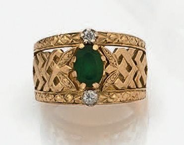 Large BAGUE en or jaune (750 millièmes) ciselé et ajouré à motifs géométriques, serti d'une chrysoprase ovale (choc) épaulée d'un diamant et une pierre blanch
