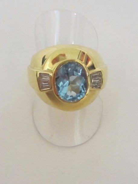 . Large BAGUE en or jaune (750 millièmes) godronné serti d’une topaze de forme coussin épaulée de six diamants baguettes.
