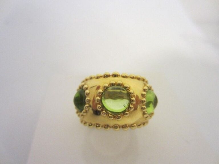 Large BAGUE en or jaune (750 millièmes) poli et boulé serti de trois péridots cabochon