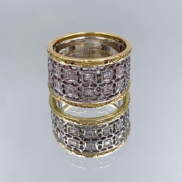 Large BAGUE en or jaune et or gris (750 millièmes) ciselé, ajouré, serti de quatorze diamants taille brillan
