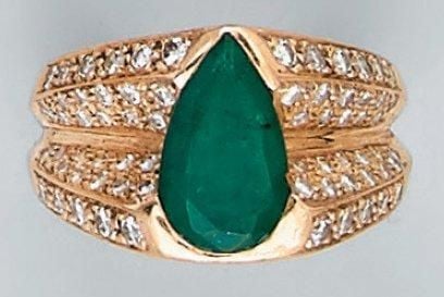 Large BAGUE en or jaune serti d'une émeraude de forme poire (choc) entourée d'un pavage de diamant