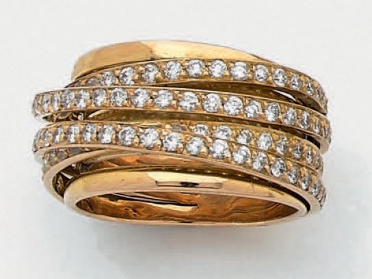 Large BAGUE en or rose (750 millièmes) ajouré, composée d'anneaux dont quatre sertis de diamants taille brillan