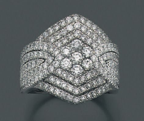 Large BAGUE géométrique en or gris (750 millièmes) pavé de diamants, dont sept, au centre, légèrement plus important