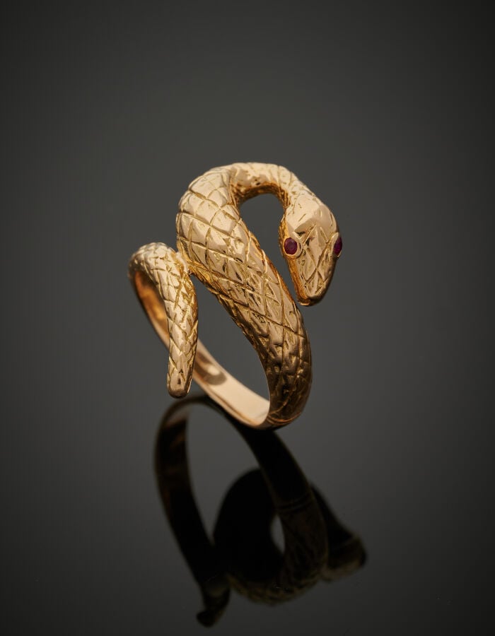 Large BAGUE "serpent" en or jaune (750‰) ciselé. Les yeux sertis de rubis ronds…