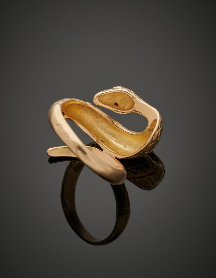 Large BAGUE "serpent" en or jaune (750‰) ciselé. Les yeux sertis de rubis ronds…