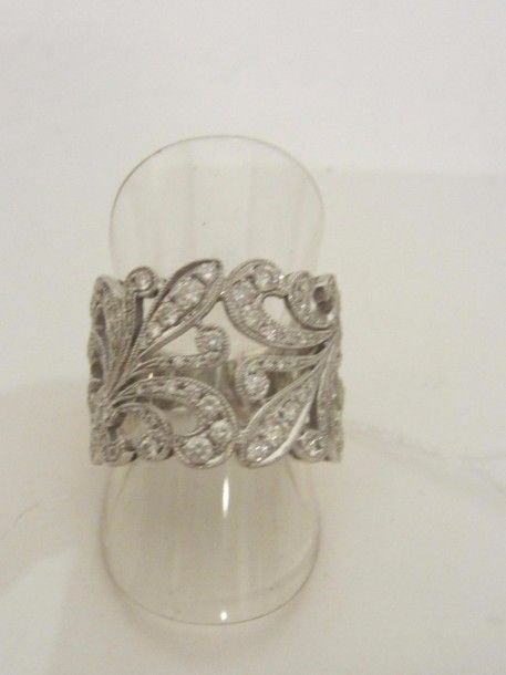 Large BAGUE « volutes » en or gris (750 millièmes) ajouré serti de diamants taille brillan