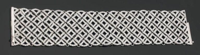 Large BRACELET « manchette » en or gris ajouré et articulé serti de diamants, à motifs losangique