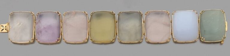 Large BRACELET MANCHETTE en or jaune (750 millièmes) articulé, serti de huit quartz et calcédoines divers, alternés, de forme coussi