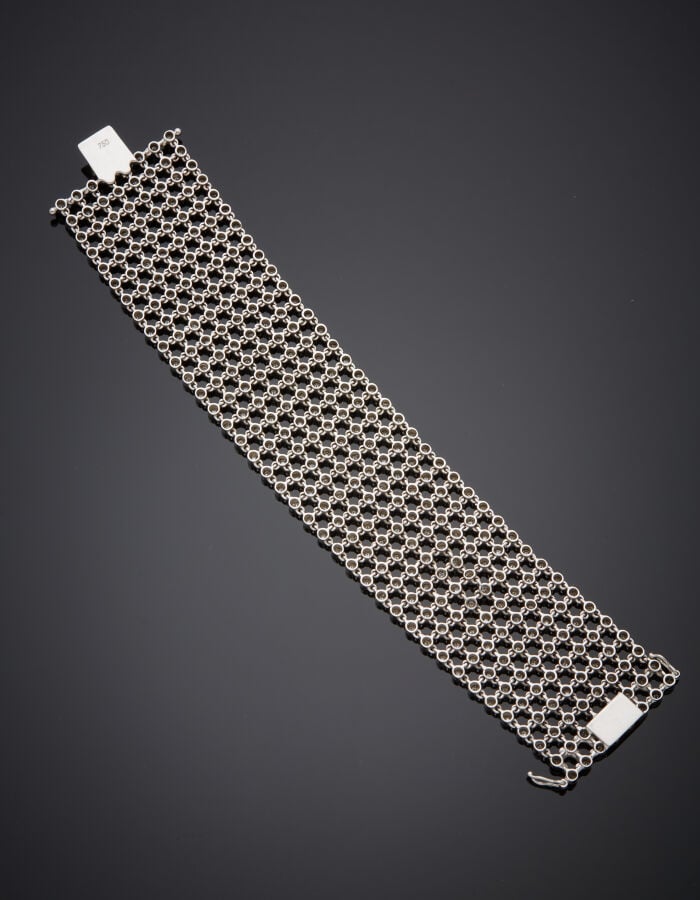 Large BRACELET manchette "résille" or gris (750‰) articulé et ajouré, serti de…