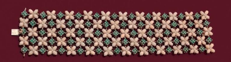 Large BRACELET MANCHETTE souple «fleurettes» en or rose 14 carats (585 millièmes) ajouré et articulé, serti de cabochons de corail, d'émeraudes et petits diamant