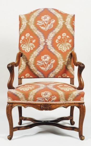 Large fauteuil à haut dossier, en noyer mouluré et sculpté de coquilles sur les prises d'accotoirs et la traverse avan
