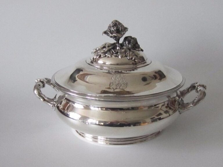 Légumier ou soupière en argent (950 ‰) en argent uni à deux anses feuillagées ; le couvercle monogrammé surmonté d’une prise en forme de brocoli