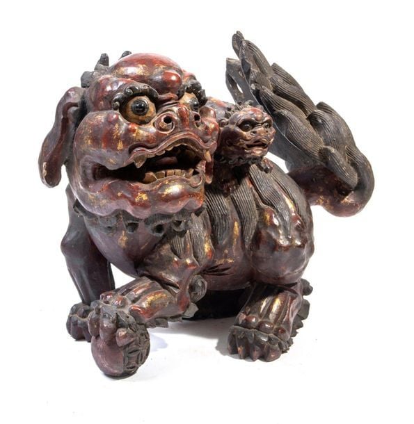 Lion shishi en bois posant sa patte sur une sphère, un petit sur le do