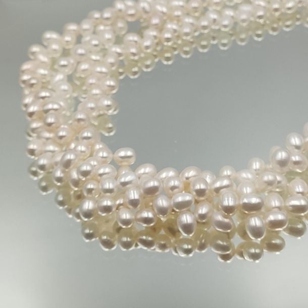 •Long COLLIER composé de trois rangs de perles de culture blanches d'eau douce, de forme oval