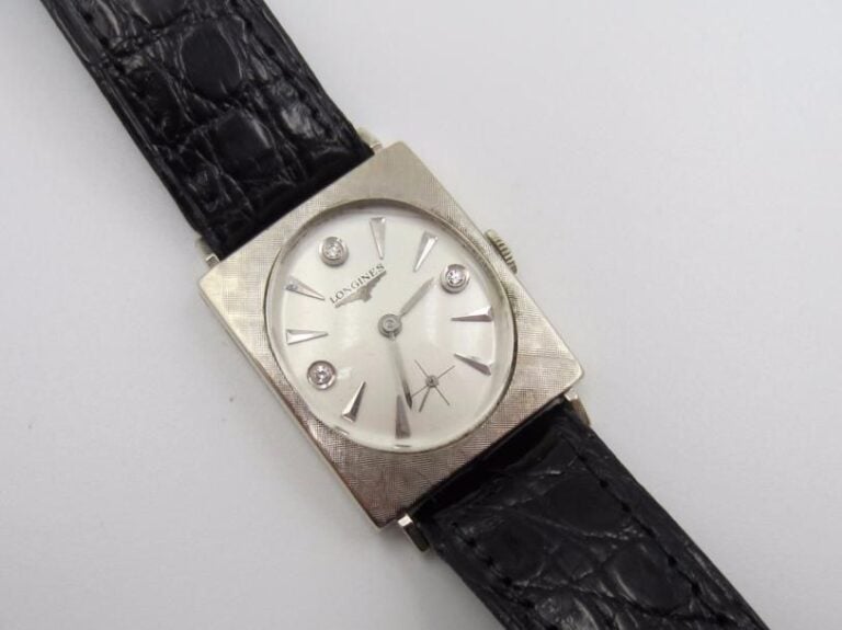 LONGINES BRACELET MONTRE en or gris 14 carats (585 millièmes), boîtier rectangulaire Lunette finement guillochée, index diamants, trotteuse à 6h Bracelet cuir Mouvement mécanique, cadran et boîtier signés LONGINES Dim du boîtier : 28 x 23 mm Poids brut : 26,2 g