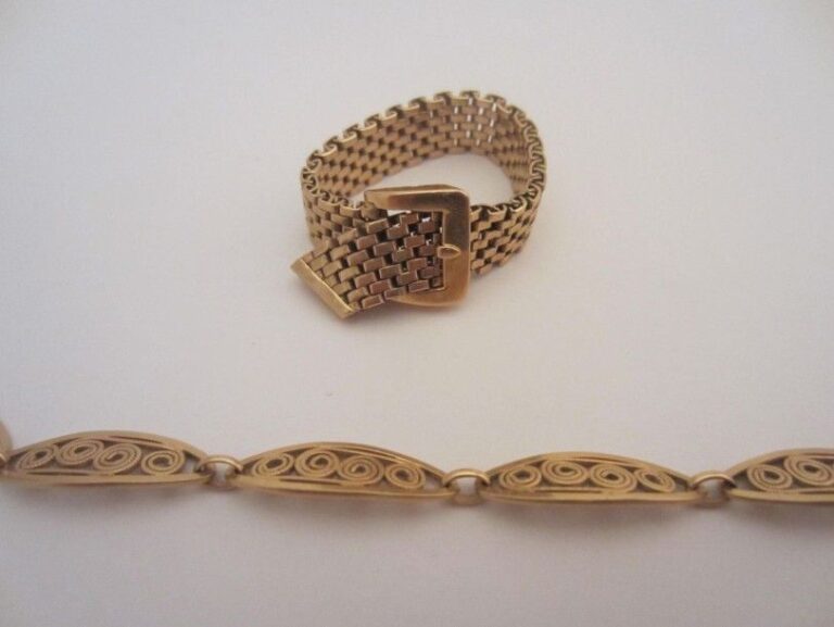 Lot comprenant: Un bracelet en or jaune (750 mill) à maillon,s ovales ajouées d'un motif filigrané spiralé et d'une bague "ceinture" en or jaune (750 mill) à maillons souple