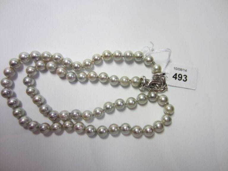 LOT comprenant: - un COLLIER composé d'un rang de perles de culture grises d'eau douc
