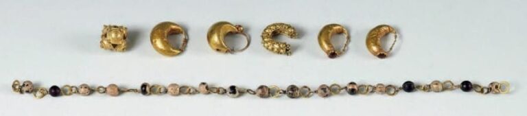 Lot comprenant une paire de boucles d'oreilles ornées d'un cabochon de grenat, trois boucles d'oreilles dépareillées, un élément de bijoux et un collier composé d'anneaux d'or reliés avec des perles globulaires en verr