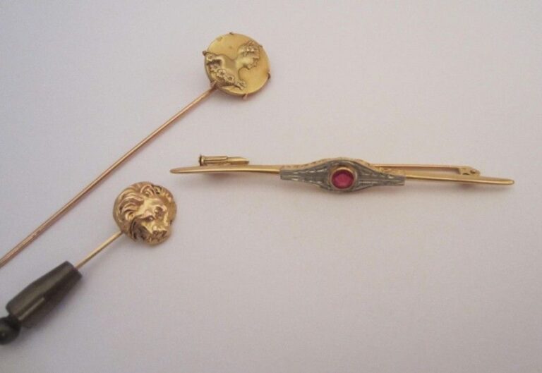 Lot de 2 épingles en or jaune (750 mill): tête de lion, buste de femme, et une broche en or jaune serti d'une pierre ros