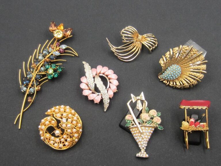 Lot de 7 broches style 1950, dorées ornées de pierres de couleur ou perles, dont BOUCHER, AVON et WEIS
